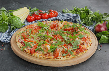 Italian concept, Italian cuisine. pizza with caviar and arugula on a black background with fresh vegetables and herbs. Rustic.