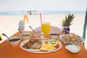 plato de comida  con salsas a la orilla de la playa 