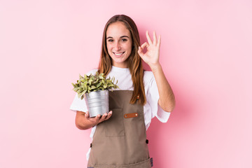 Young gardener caucasian woman isolated cheerful and confident showing ok gesture.