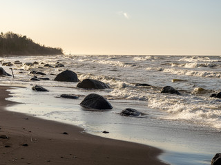 Fototapeta na wymiar backlit landscape with stony sea shore