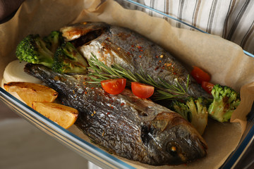 Baking tray with tasty dorado fish, close up 