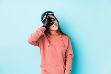 Young skier woman isolated excited keeping ok gesture on eye.