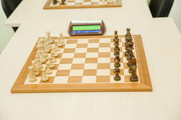 Chess board with aligned figures and a clock before the game