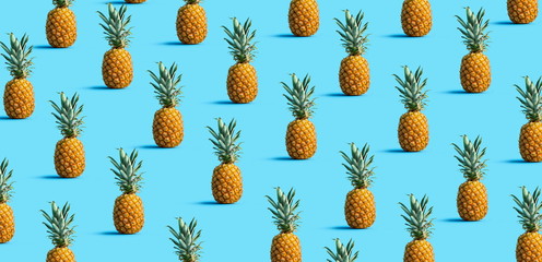 Many pineapples on a solid color background