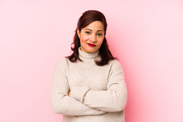 Middle age latin woman isolated on a pink background unhappy looking in camera with sarcastic expression.