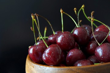 Спелая красная черешня на черном фоне крупным планом