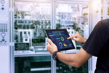 Smart industry control concept.Hands holding tablet on blurred automation machine as background - obrazy, fototapety, plakaty