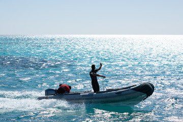 Fototapeta premium Man rushing in inflatable boat in sea