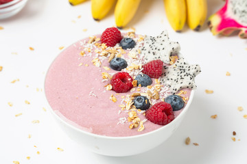 Healthy breakfast bowl: blueberry smoothie with raspberries, bananas, pitaya and granola. 