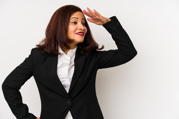 Middle age latin business woman isolated looking far away keeping hand on forehead.