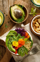 Buddha bowl of mixed vegetables, quinoa and edible flowers, top view.  Healthy and nutritious vegan meal
