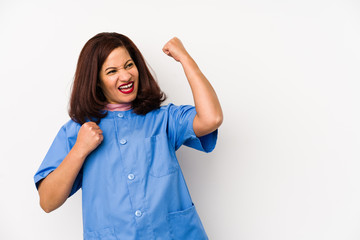 Middle age latin nurse woman isolated çraising fist after a victory, winner concept.