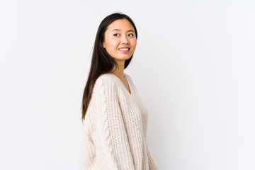 Young chinese woman isolated looks aside smiling, cheerful and pleasant.