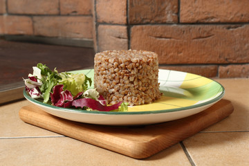 Cooked buckwheat porridge with salad on plate