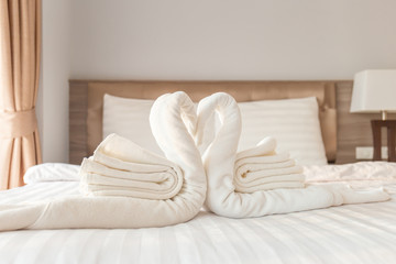 Fototapeta na wymiar Towel folded in swan shape on bed sheet in bed room