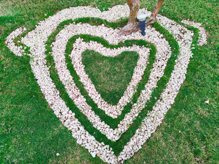 Top view  of heart shape white stones on the grass for landscape design. Backdrop for Valentine’s...