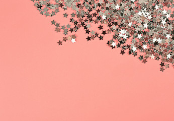 Silver glitter stars on pink background. Festive holiday pastel backdrop.