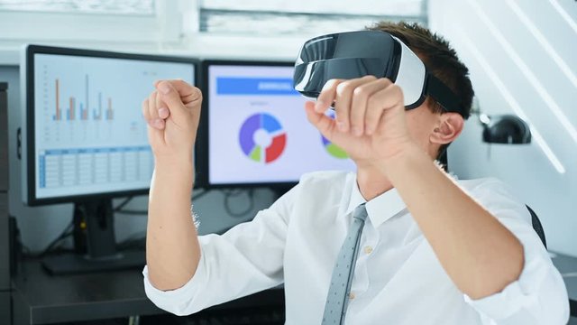 Trader Man With VR Headset Looking On Virtual Stock Chart. Business And Communication Concept. Slow Motion Effect