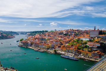 Portugal, Douro river, wonderful panoramic view of Porto, tourist centre of Porto,  clear sunny day in Porto, light white clouds over Porto, colorful houses with red roofs in Porto