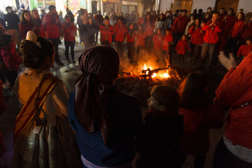 Fallas in Valencia. Group of people dance by the fire. End of the party.