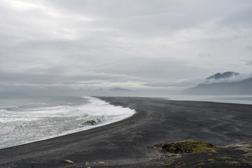 View over Atlantic ocean and Hvalnes beach next to the Ring road in Iceland. Tourists walks on the beach.
