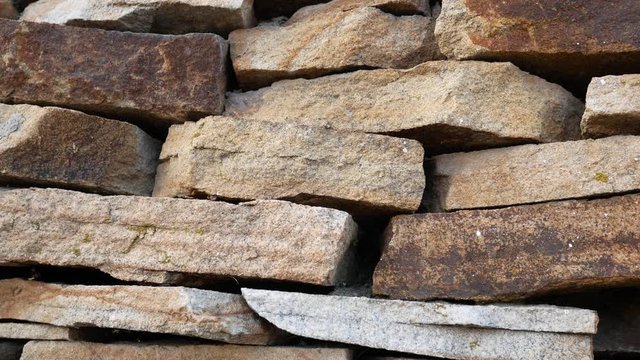 A wall of large flat sand-colored stones.  Stone texture concept