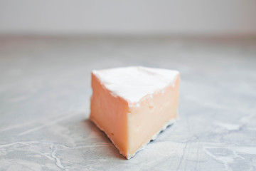 Camembert cheese on a table with vegetables