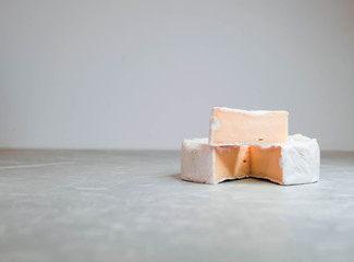 Camembert cheese on a table with vegetables