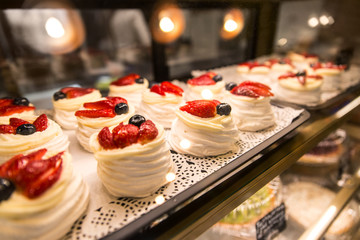 showcase with delicious fresh pastries decorated with fresh berries. dessert in a cafe