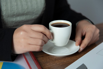 woman hand cup of coffee with notepad