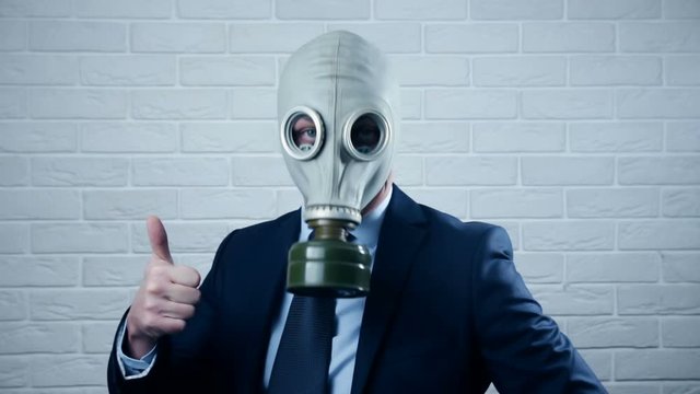 Portrait of businessman in gas mask and suit with thumb up. Thumb up from cheerful businessman