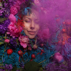 Female portrait in fairy tale stylization surrounded with natural flowers.