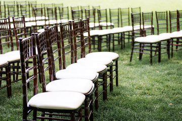 Rows of wooden padded chairs outdoors