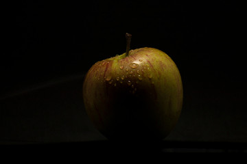 Fresh green apple closeup over black background