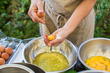 Woman in apron separating egg yolks from whites