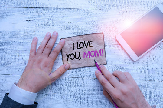 Word writing text I Love You, Mom. Business photo showcasing Loving message emotional feelings affection warm declaration Hand hold note paper near writing equipment and modern smartphone device