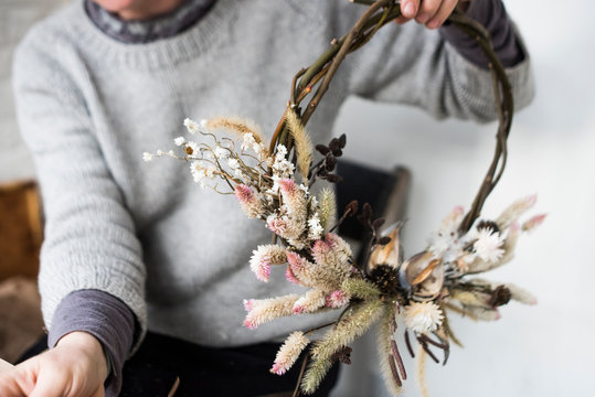 Flower farmer making decorative wreath from foraged branches and dried flowers