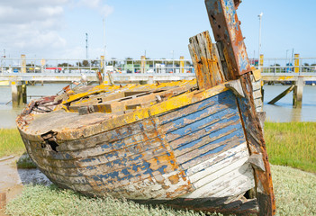 Rye Harbour, East Sussex, England. Old weathered boat sitting in the mud at low tide.