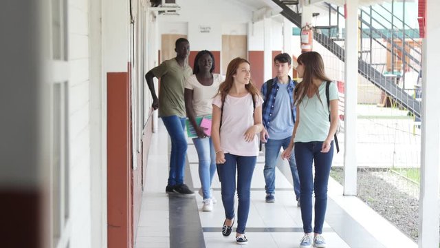 Young teenagers walking along the school hallway