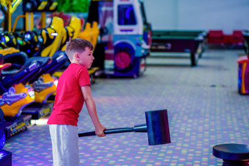 Technology, gaming, entertainment and people concept. Boy playing automatic toy hummer on playground at shopping mall. - 317567431