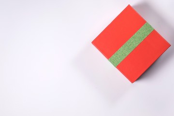 Fototapeta na wymiar Gift red box with green ribbon isolated on white background. View from above