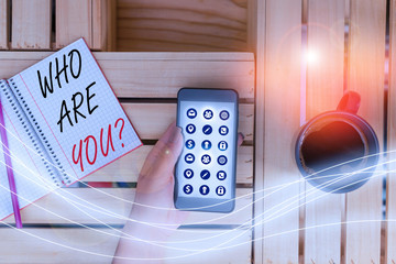 Writing note showing Who Are You question. Business concept for Identify yourself description...