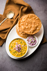 Dal pakwan is an authentic Sindhi breakfast. It is a combination of deepfried, crisp and unpuffed Maida puris served with Daal made using chana or split chickpea. selective focus