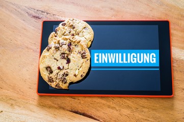 Cookies mit einem Tablet zur Verdeutlichung von Cookie Bannern für Websites mit auf deutsch...