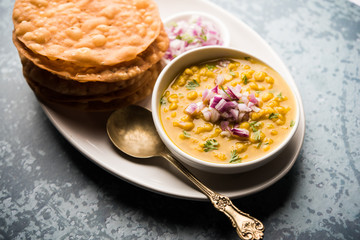 Dal pakwan is an authentic Sindhi breakfast. It is a combination of deepfried, crisp and unpuffed Maida puris served with Daal made using chana or split chickpea. selective focus