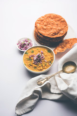 Dal pakwan is an authentic Sindhi breakfast. It is a combination of deepfried, crisp and unpuffed Maida puris served with Daal made using chana or split chickpea. selective focus