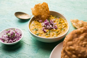 Dal pakwan is an authentic Sindhi breakfast. It is a combination of deepfried, crisp and unpuffed Maida puris served with Daal made using chana or split chickpea. selective focus