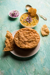Dal pakwan is an authentic Sindhi breakfast. It is a combination of deepfried, crisp and unpuffed Maida puris served with Daal made using chana or split chickpea. selective focus