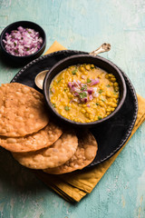Dal pakwan is an authentic Sindhi breakfast. It is a combination of deepfried, crisp and unpuffed Maida puris served with Daal made using chana or split chickpea. selective focus