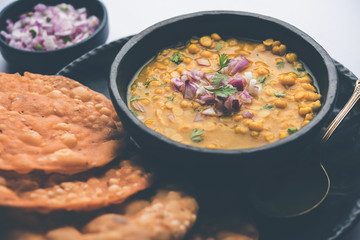 Dal pakwan is an authentic Sindhi breakfast. It is a combination of deepfried, crisp and unpuffed Maida puris served with Daal made using chana or split chickpea. selective focus